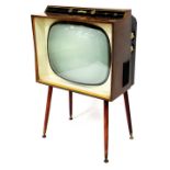 A vintage Defiant teak cased television, with 17 inch screen on turned legs terminating in