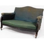 A late 19thC ebonised settee, with serpentine top, overstuffed back, arms and seat and carved