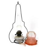 A Victorian hanging oil lamp, the part cranberry tinted shade decorated with flowers, etc., with