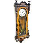 A late 19thC twin weight walnut and ebonised Vienna wall clock, the shaped case with a glazed door