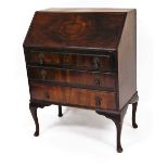 A mid 20thC walnut bureau, the fall front revealing a fitted interior raised above three long