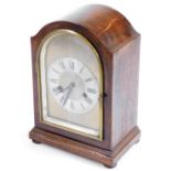 An Edwardian oak mantel clock, in domed case with silvered 11cm diameter chaptering, on compressed