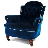 A Victorian low armchair, with buttoned velvet upholstery and turned fore legs.
