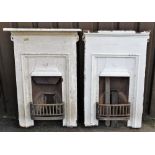 A pair of Victorian cast iron fireplaces, each of rectangular form in white, with central openings