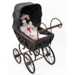 A Victorian style doll's pram, with adjustable canopy on a wrought iron base with two sized wheels