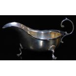 A George V silver sauce boat, with flared rim, flying S scroll handle and triple hoof feet,
