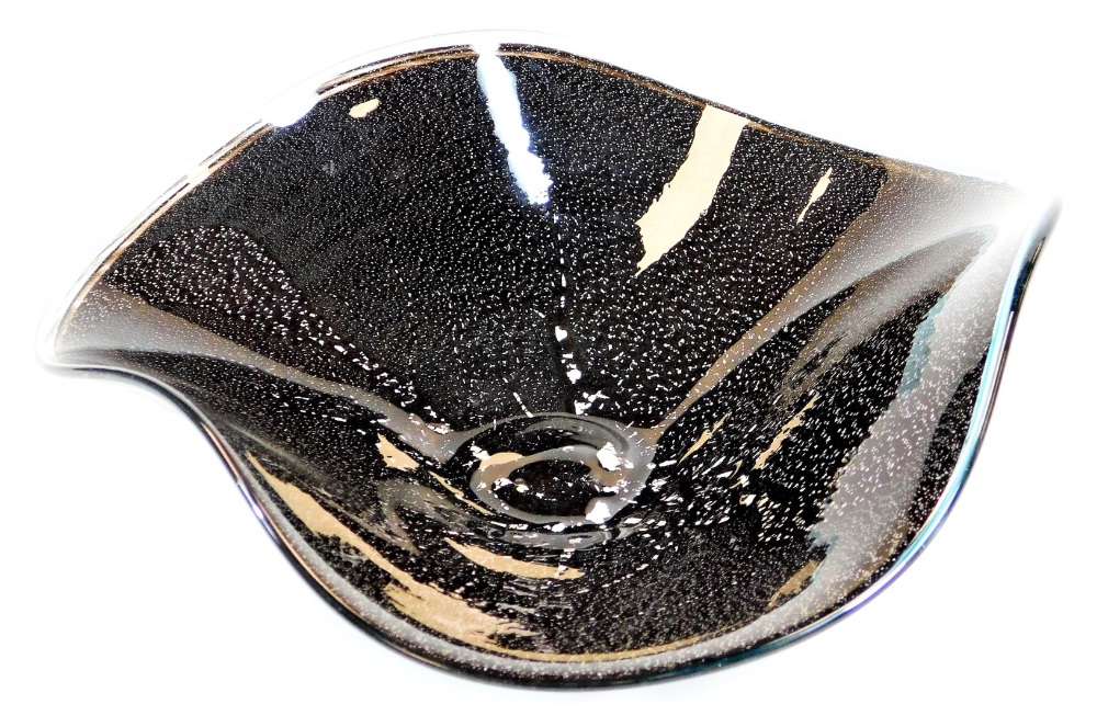 A 20thC studio Our Glass dish, of clover leaf form, in black and white speckled decoration, on