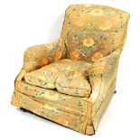 A Victorian deep seated low armchair, in the manner of Howard & Sons, with floral loose covers,