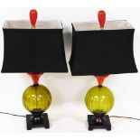 A pair of table lamps, in green glass on platform bases with blue shades surmounted by red bulbs,