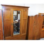 An Edwardian mahogany wardrobe, with single door flanked by two panels raised above drawer beneath