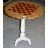 A leather topped and parquetry games table, on cream painted turned stem, terminating in triple