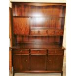 A Stag display cabinet, with fixed shaped cornice, raised above open shelves, drawers and