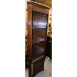 An Old Charm style oak finish freestanding corner cabinet, with open shelves raised above cupboard