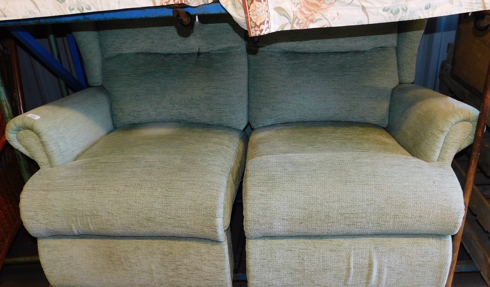 A modern two seater reclining settee, in green material.