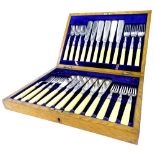 A set of six silver plated and simulated ivory fish knives and forks, in oak case with vacant cartou
