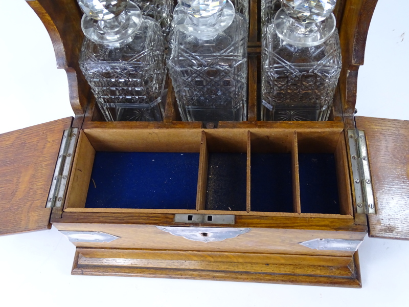 A late 19th/early 20thC oak and silver plated tantalus, with three square section decanters, a hinge - Image 2 of 2