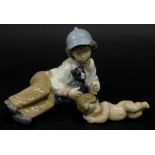 A Lladro porcelain reclining angel or cherub, and a Nao porcelain figure of a young boy reclining wi