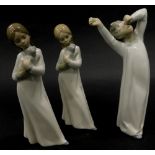 A Lladro porcelain figure of a young boy wearing a night dress yawning, and two similar Nao figures