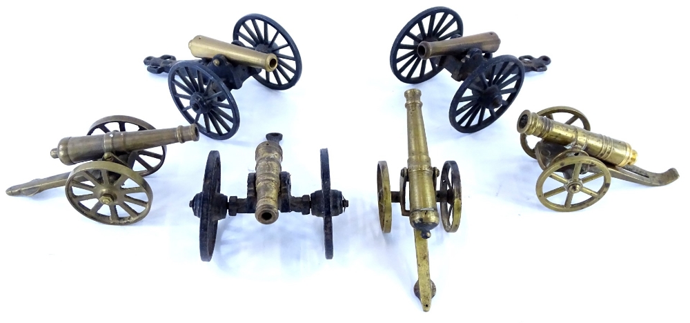 A collection of miniature brass cannon, to include three on ebonised cast iron bases.