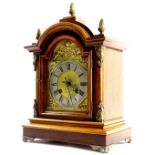 An early 20thC German walnut mantel clock, the arched brass dial with a silver chapter ring, the mah