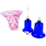 A pair of blue and clear glass ornamental bells, and a cranberry tinted cut glass vase of tapering f