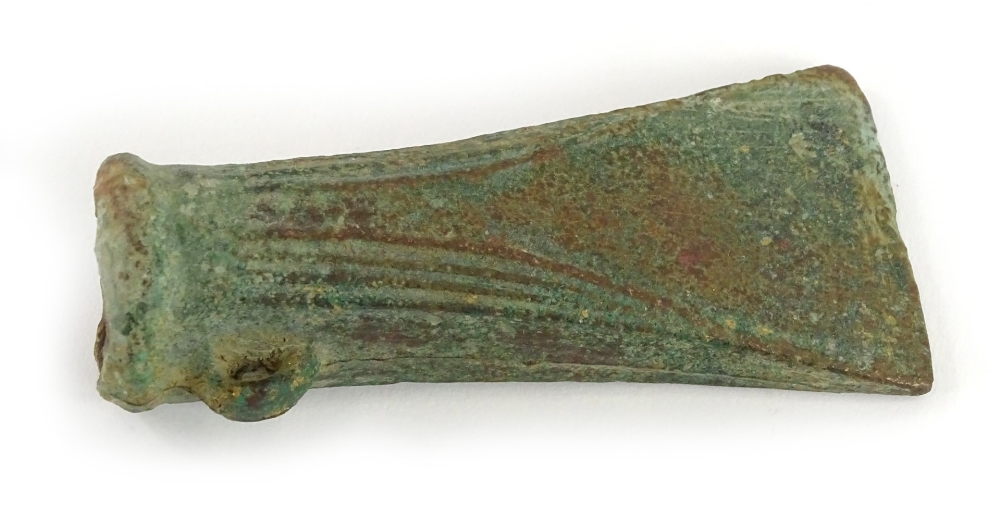 A Bronze Age bronze socket axe head, with reeded decoration to the sides, loop, etc. 10cm long. Pro