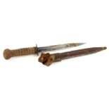 An early 20thC dagger, with unmarked blade, turned hardwood handle with indistinct monogram, the lea
