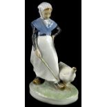 A Royal Copenhagen porcelain figure, model in the form of a lady with a goose, on oval base, printe