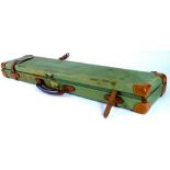 A canvas and leather shotgun case, 82cm wide.