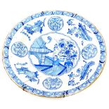 An 18thC English Delft large plate, decorated with oriental figures, buildings, vases, etc., (AF), 3