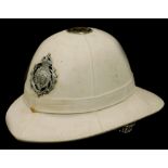 A WWI British colonial service pit helmet, with chrome plated badge and white painted canvas interio