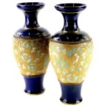 A pair of Doulton Lambeth Slaters patent vases, each with cobalt blue bands and typical flower and l