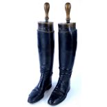 A pair of black riding boots with trees, stamped Rowell & Sons of Melton Mowbray.