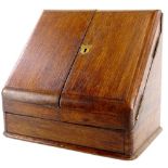 An Edwardian oak slope top stationery cabinet, the hinged lid enclosing a fitted interior with an in