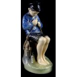 A Royal Copenhagen porcelain figure, model in the form of a young fisherman with a knife, seated on