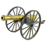 A gilt brass effect miniature cannon, the carriage initialled CSA, with spoked wheels, 62cm long ove