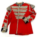 A vintage Coldstream Guards drummers tunic, in red with applied fleur de lys piping.