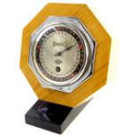 An Art Deco Day Dial calendar, with clockwork mechanism, in figured wooden octagonal case and ebonis