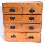 A pine chest of drawers, plain form with two short and three long drawers, each with art nouveau sty