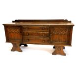 An Old Charm type oak low sideboard, with an arrangement of three drawers flanked by two carved Goth