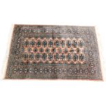 An Afghan type rug, with a design of two rows of medallions on a pink ground, with multiple borders,