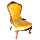 A Victorian walnut nursing chair, with a carved show frame, upholstered in buttoned gold velvet on c