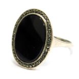 A silver onyx and marcasite set dress ring, with oval onyx stone, surrounded by a tiny marcasite, ri