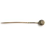 A Victorian diamond set stick pin, with small circular flower design head, on a yellow metal pin, un