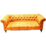 A Victorian mahogany Chesterfield sofa, reupholstered in geometric orange and multicoloured fabric,