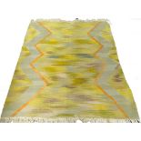 A South African wool flatweave rug, in a shaded yellow, green and purple centre, with a yellow band,