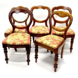 A set of five Victorian mahogany balloon back chairs, each with a drop in seat upholstered in floral