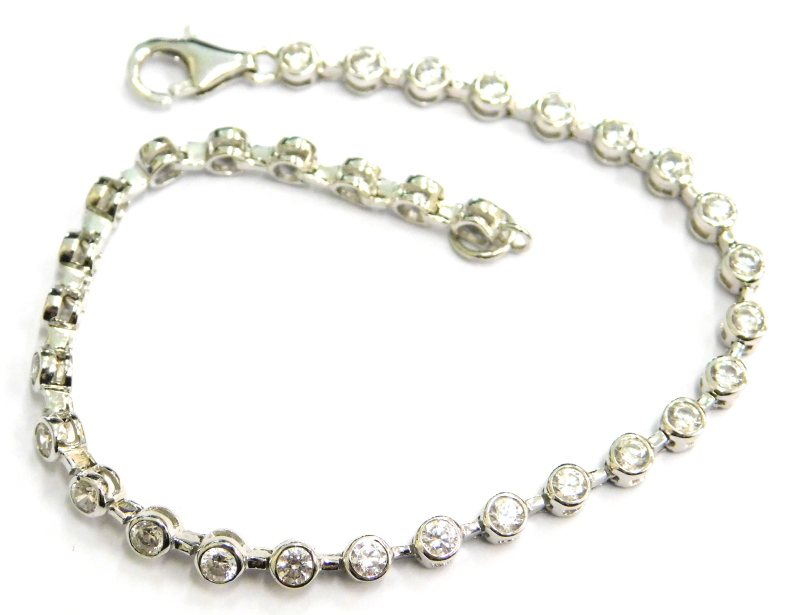 A modern stone set bracelet, set with circular set paste stones, in a silver coloured setting, unmar