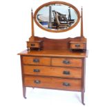A late 19th/ early 20thC walnut dressing table, the oval bevelled plate on tapering supports, the to