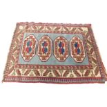 A Persian Kazak type rug, with a design of three medallions in blue and red on a pale blue ground, a